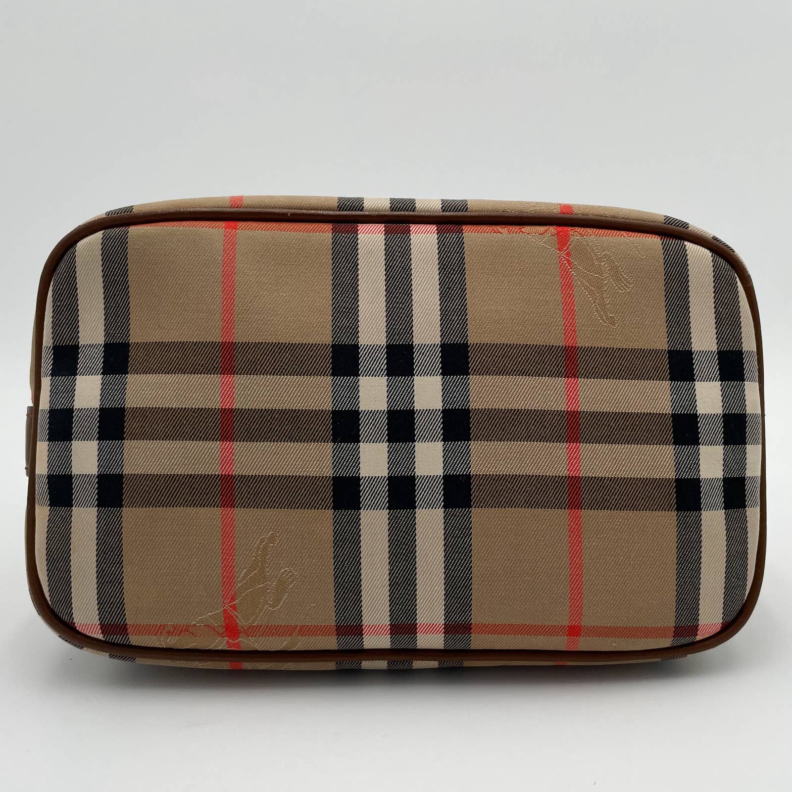 This Burberry Vintage House Check Bag showcases a rectangular design with the iconic beige, black, white, and red plaid pattern. The bag features brown edges and trim made of canvas with leather trim and a convenient zip top for easy access.