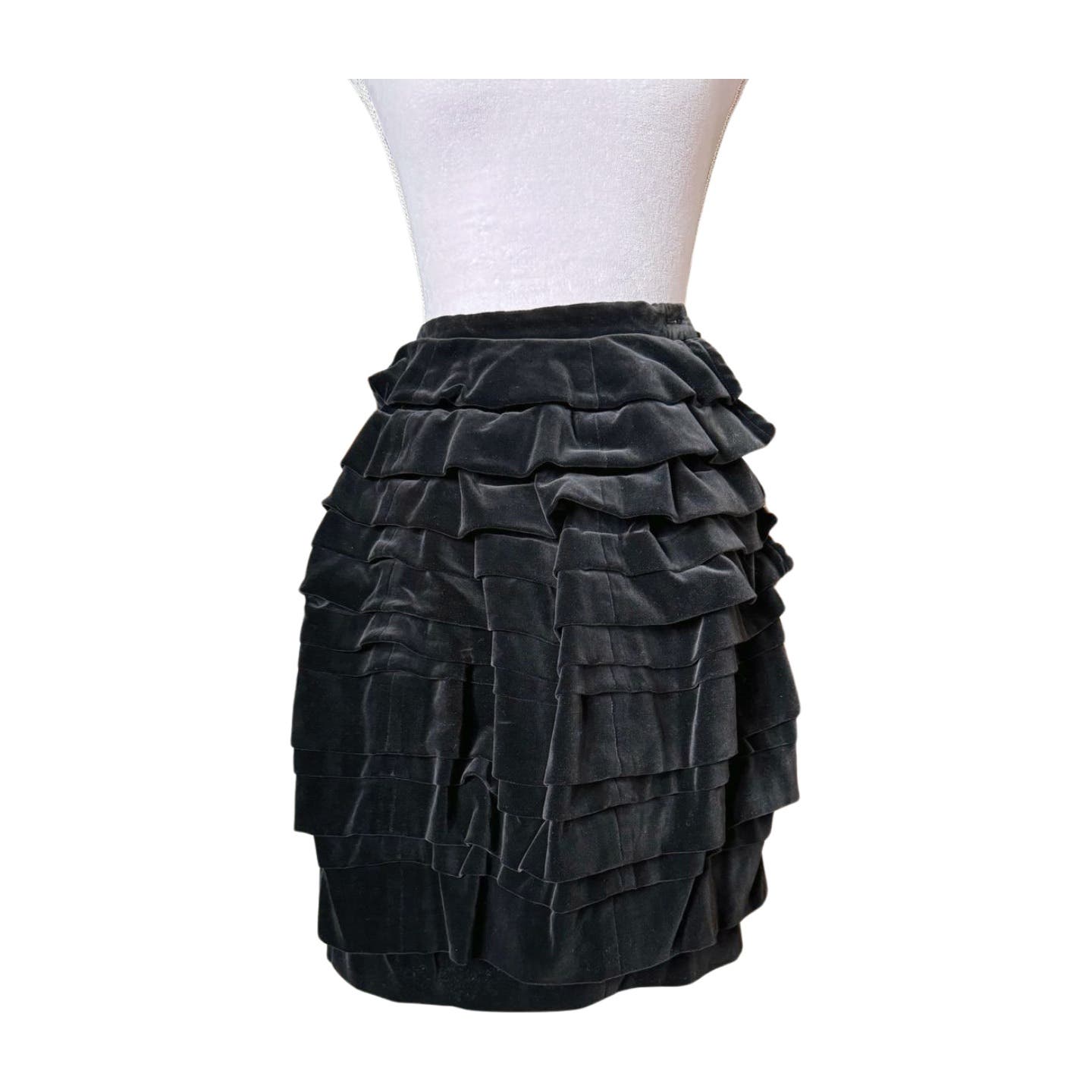 A Vintage 1990 Comme des Garçons Skirt with several horizontal ruffled layers displayed on a white mannequin torso. The knee-length skirt, reminiscent of a 90s Comme des Garçons piece, features a fitted waist and is in impeccable vintage condition.