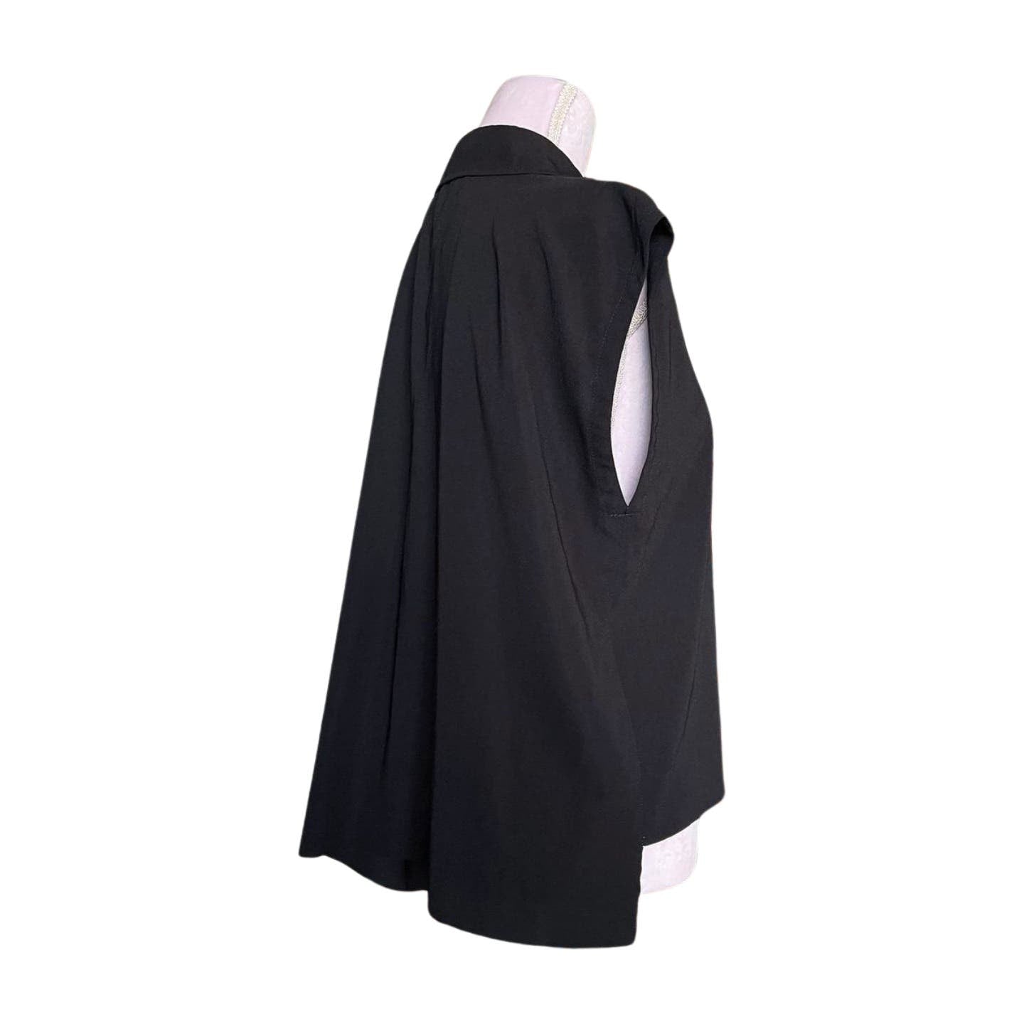 A mannequin is dressed in a sleeveless black top with a high collar and a flowing, cape-like back, reminiscent of Comme des Garçons' innovative designs. The image shows a side profile view, highlighting the Vintage 1992 Comme des Garçons Asymmetric Top's loose, draped fit made from soft polyester tricot. The background of the image is white.