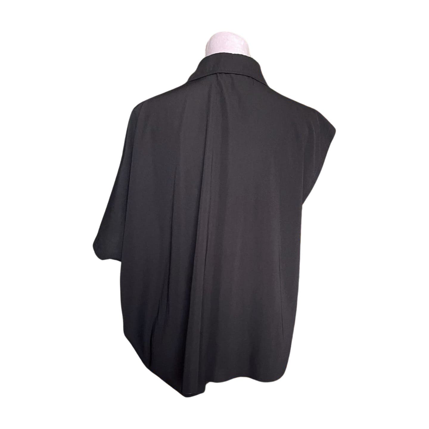 A black, short-sleeve Vintage 1992 Comme des Garcons Asymmetric Top displayed on a mannequin, viewed from the back. The lightweight, relaxed-fit top is made from polyester and features a collar at the top. The background is plain white.