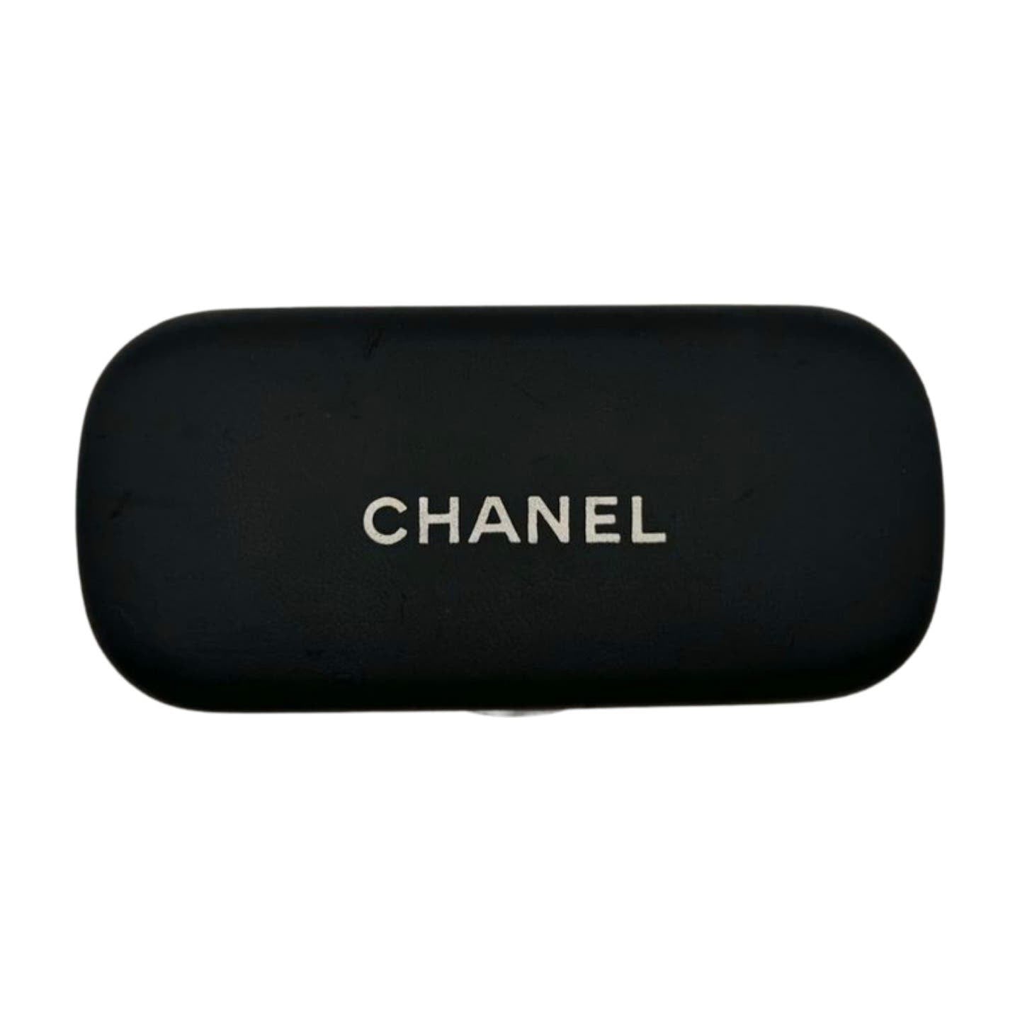 A rectangular black case with rounded edges displays the word "CHANEL" in white, capital letters at the center. This sleek and minimalist design is perfect for protecting your Vintage 90’s Chanel Sunglasses.