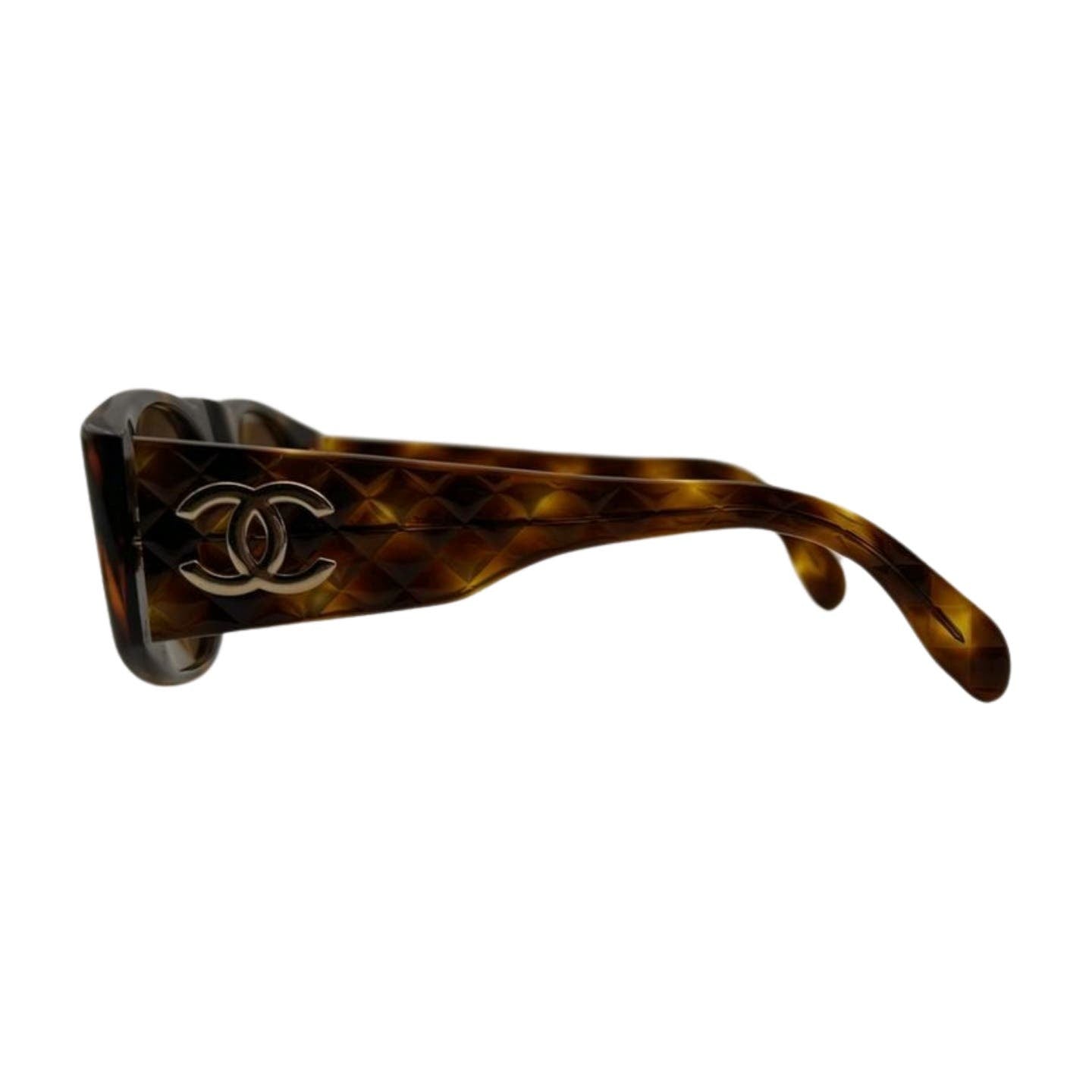 Side view of designer Vintage 90’s Chanel Sunglasses by Chanel with brown tortoiseshell frames featuring a quilted pattern. The elegant quilted arms prominently display a metallic interlocking "CC" logo, indicating the iconic brand.